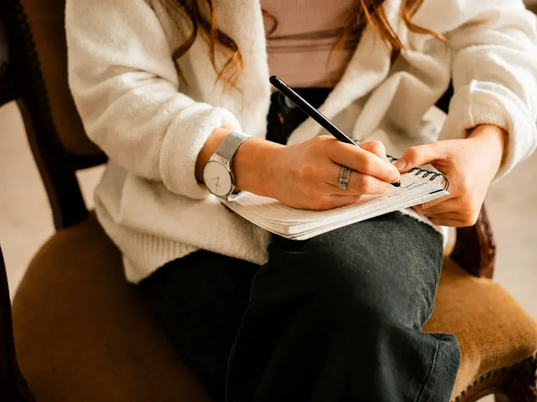 Woman writing in a notebook during a quiet moment of reflection
